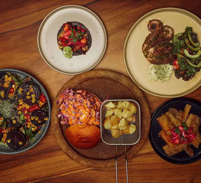 Una mesa de Azotea con tacos, pulpo y hamburguesa